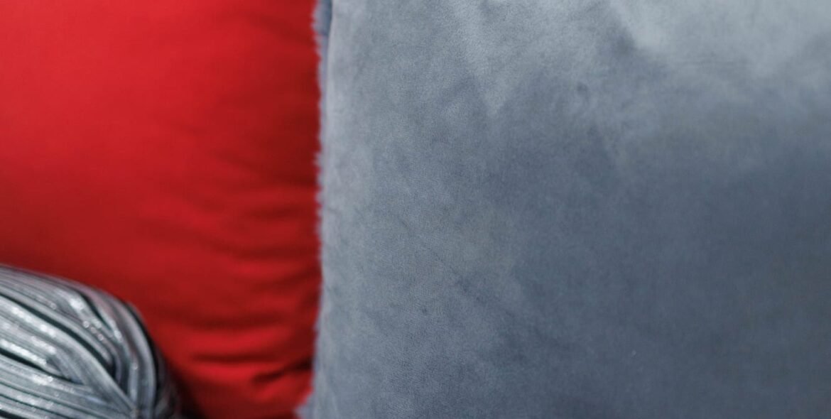 Red and grey cushions on a queen bed