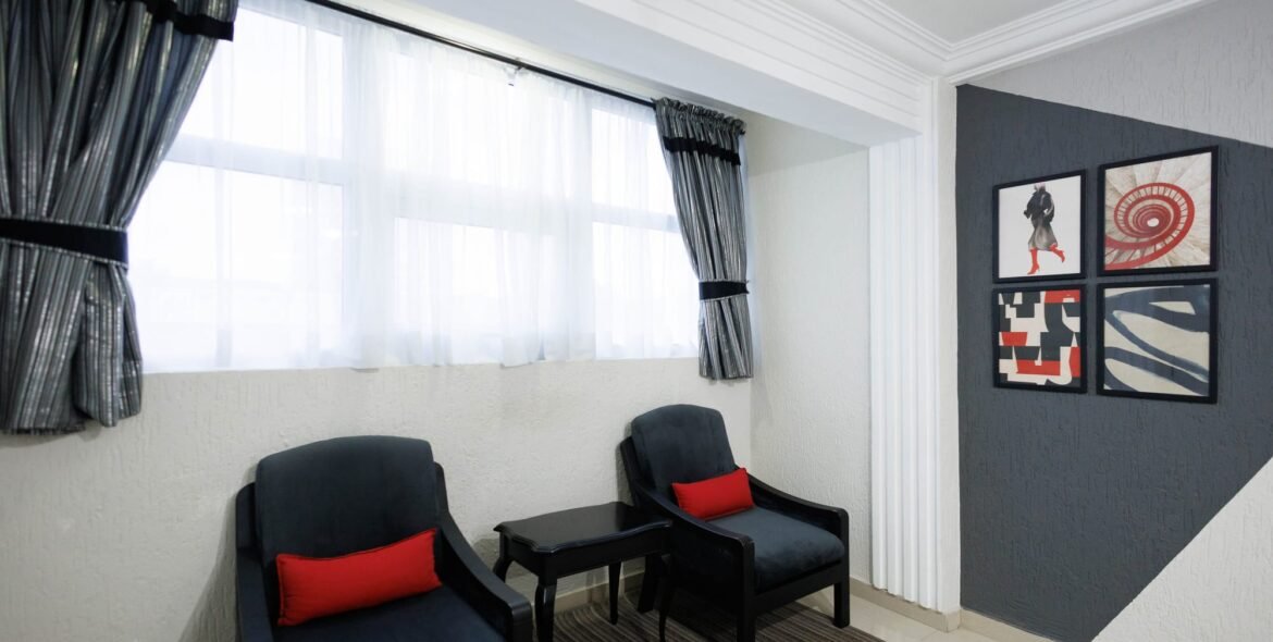 Queen-room seating beside a curtained window
