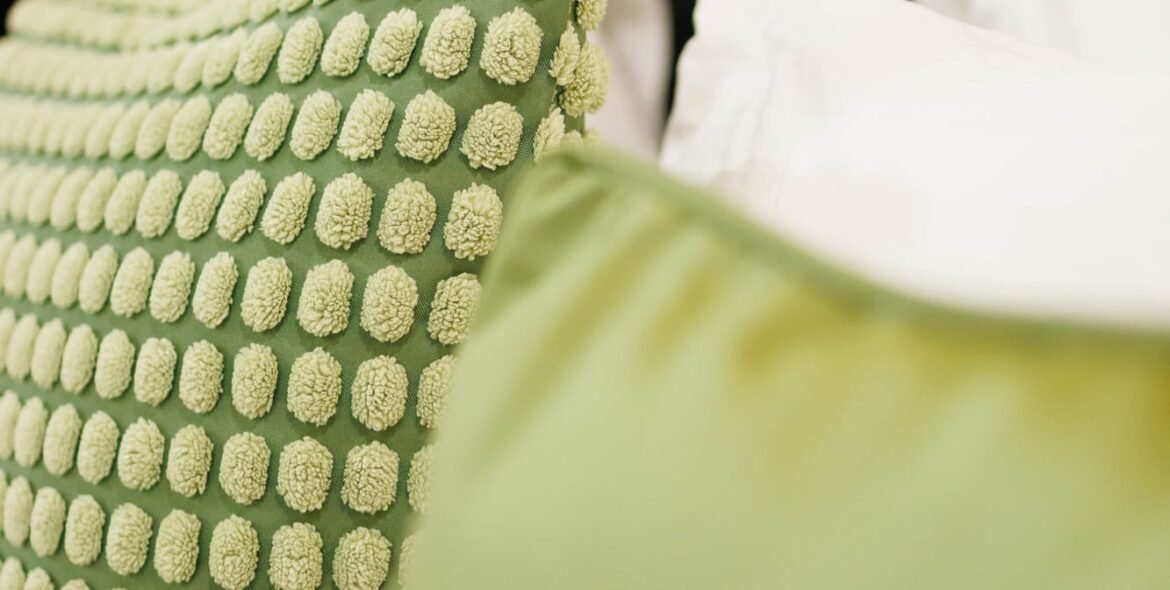Green cushion on a guest-room bed