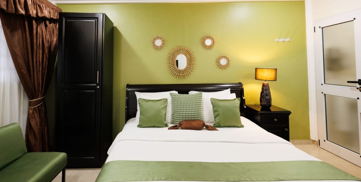 Queen bed with green cushions and matching wall