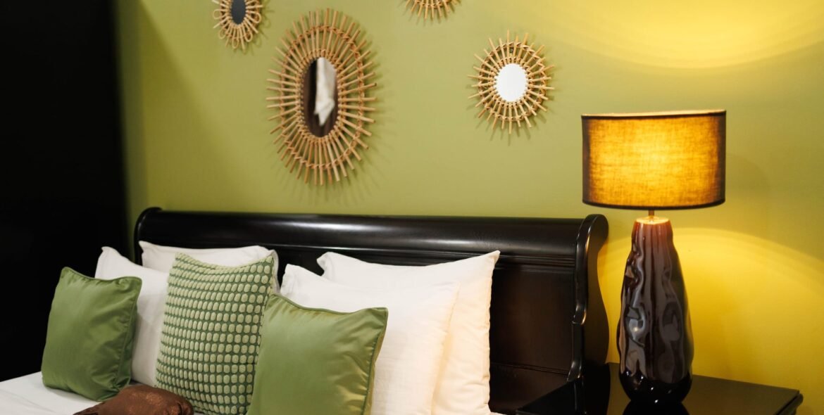 Bed and pillows beside a green guest-room wall