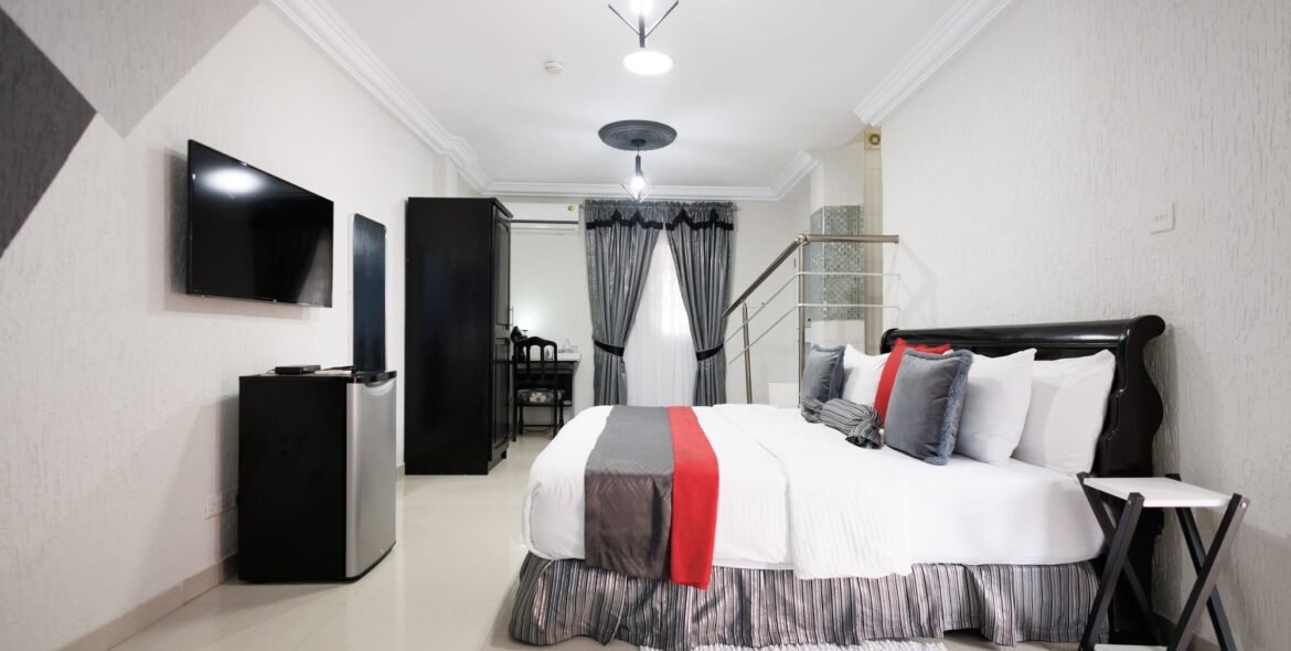 Queen bed with red and grey cushions
