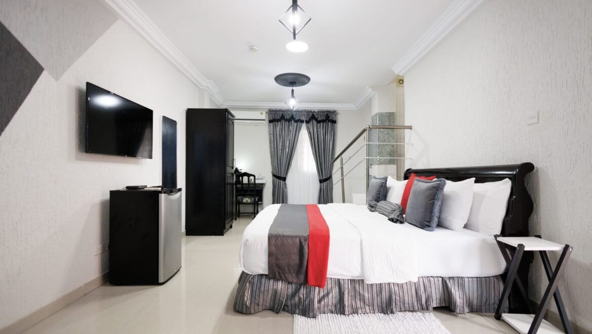 Queen bed with red and grey cushions