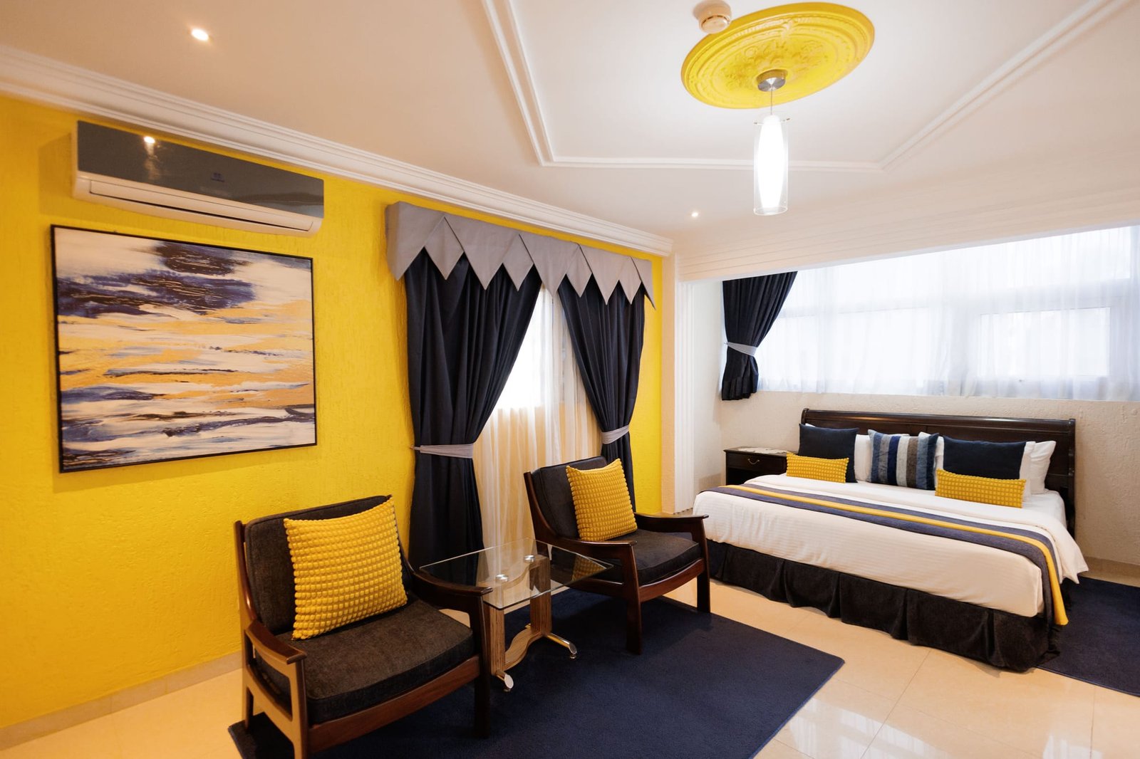 Guest room with a yellow accent wall and seating